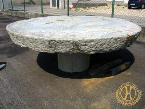 Alter Mühlstein aus Granit als Gartentisch verwendet